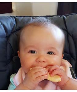 Happy Baby eating Rice Rusk